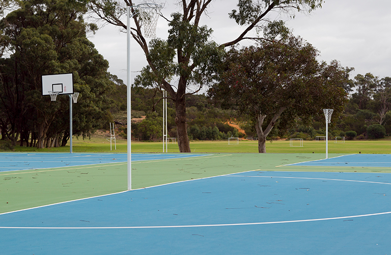 An image of the netball courts by Thomas Oval, with one of the ovals visible in the background.