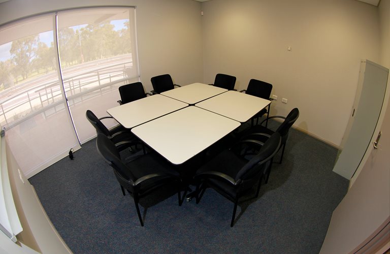 Four desks and six chairs in a meeting room in Zone Youth Space.