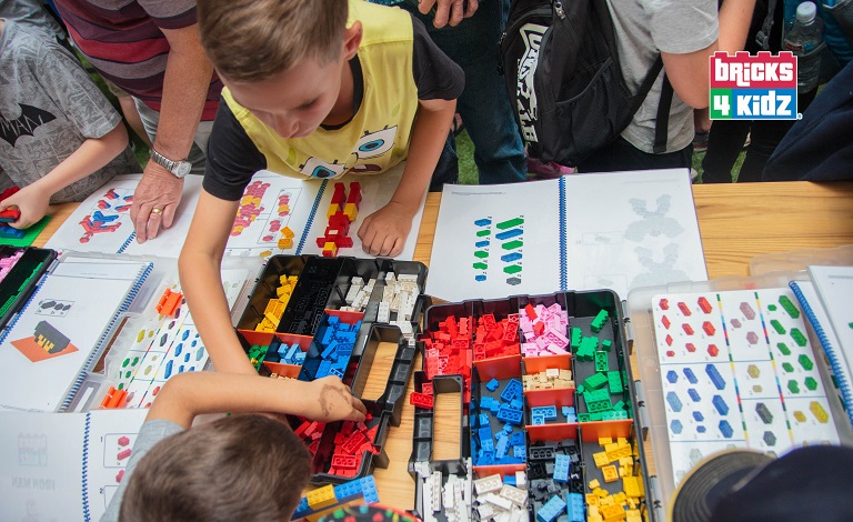 Children use Lego blocks to create structures.