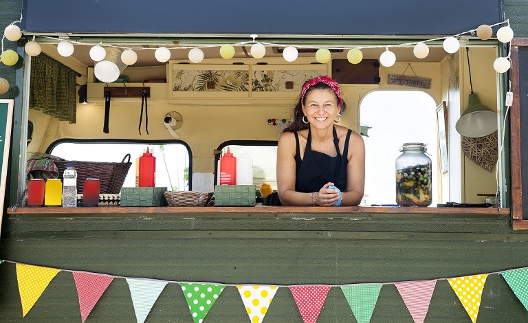 A woman smiles in a food truck.