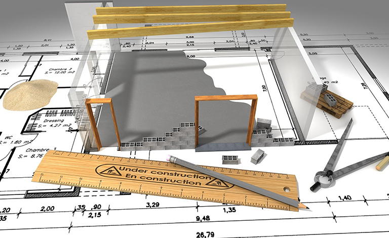 A ruler and a model of a house sit on a floorplan.