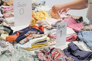 Children's clothing organised by size on a table