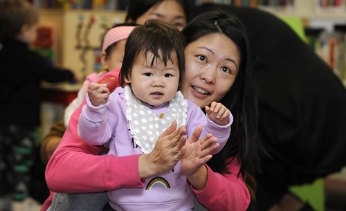 A woman holds a toddler.